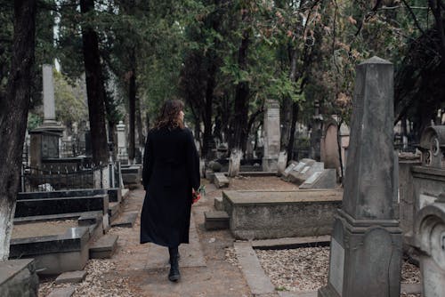 Woman in Black Dress Walking in a Cemetery