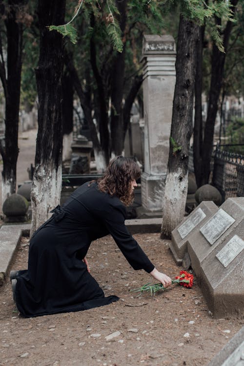 Free A Woman Offering Flowers On A Grave Stock Photo
