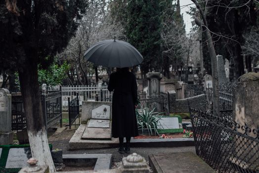 Woman in Black Dress Holding Umbrella Standing on Gray Concrete Pathway