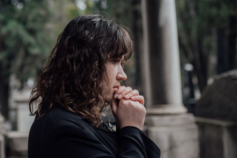 Brunette woman reflecting in a quiet setting representing grief and emotional processing