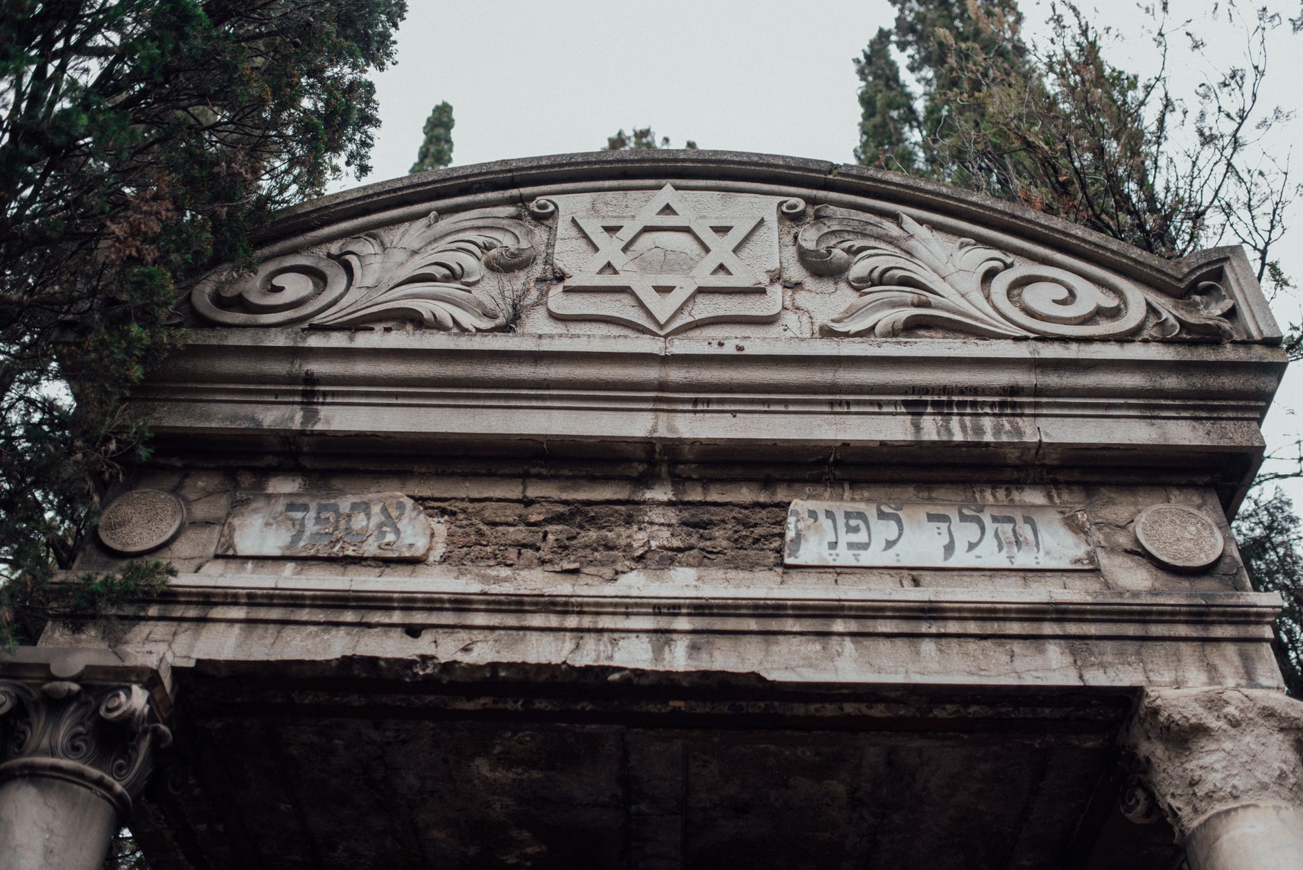 Ornate Star of David on antique stone mausoleum in Jewish cemetery.