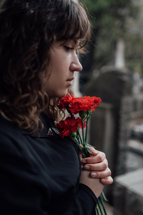 Free Woman in Black Long Sleeve Shirt Holding Red Flower Stock Photo