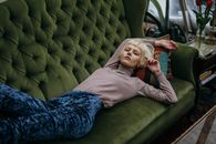 Photo of a Woman with Bleached Hair Lying on a Green Sofa