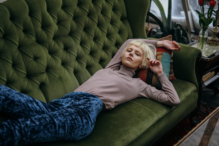 Photo Of A Woman With Bleached Hair Lying On A Green Sofa