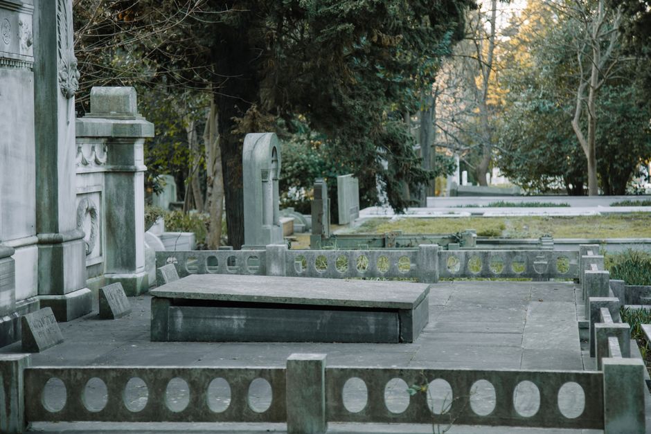 Monuments funéraires de formes variées dans un cimetière ombragé
