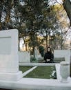 Unhappy woman on bench against gravestone in cemetery