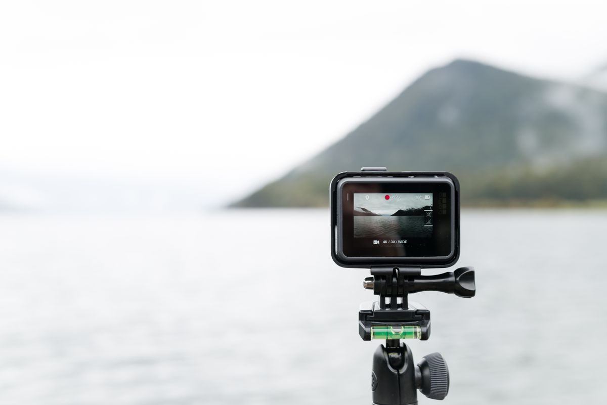 Camera de actiune pe un minitrepied filmand un lac