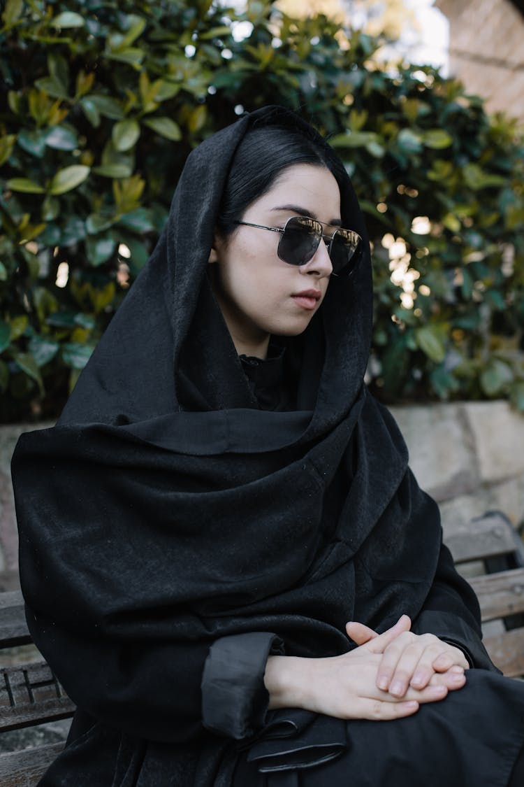 Unhappy Woman In Black Sunglasses Resting On Bench Outdoors