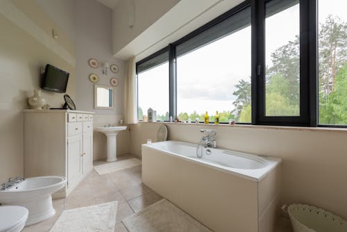 Free Interior of modern bathroom with bath near window Stock Photo