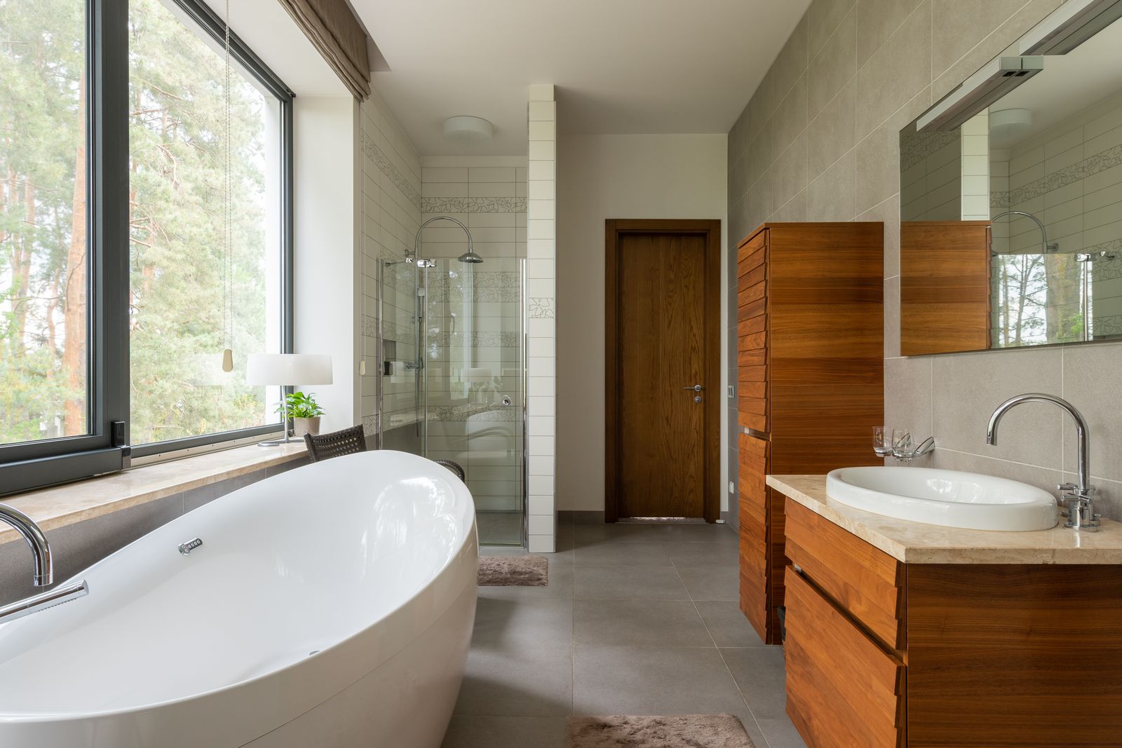 Finished bathroom remodel: freestanding tub by a picture window, walk-in shower and a timber vanity