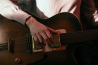 Person Playing Brown and Black Electric Guitar