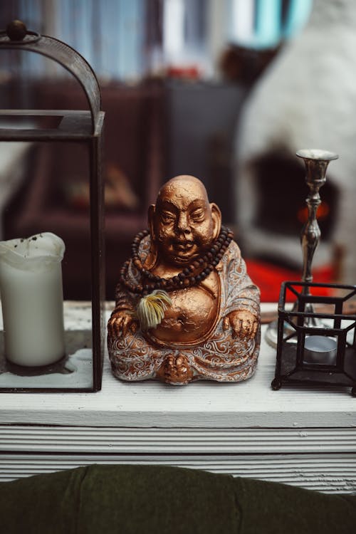 Buddha Figurine On Display Beside A Candle