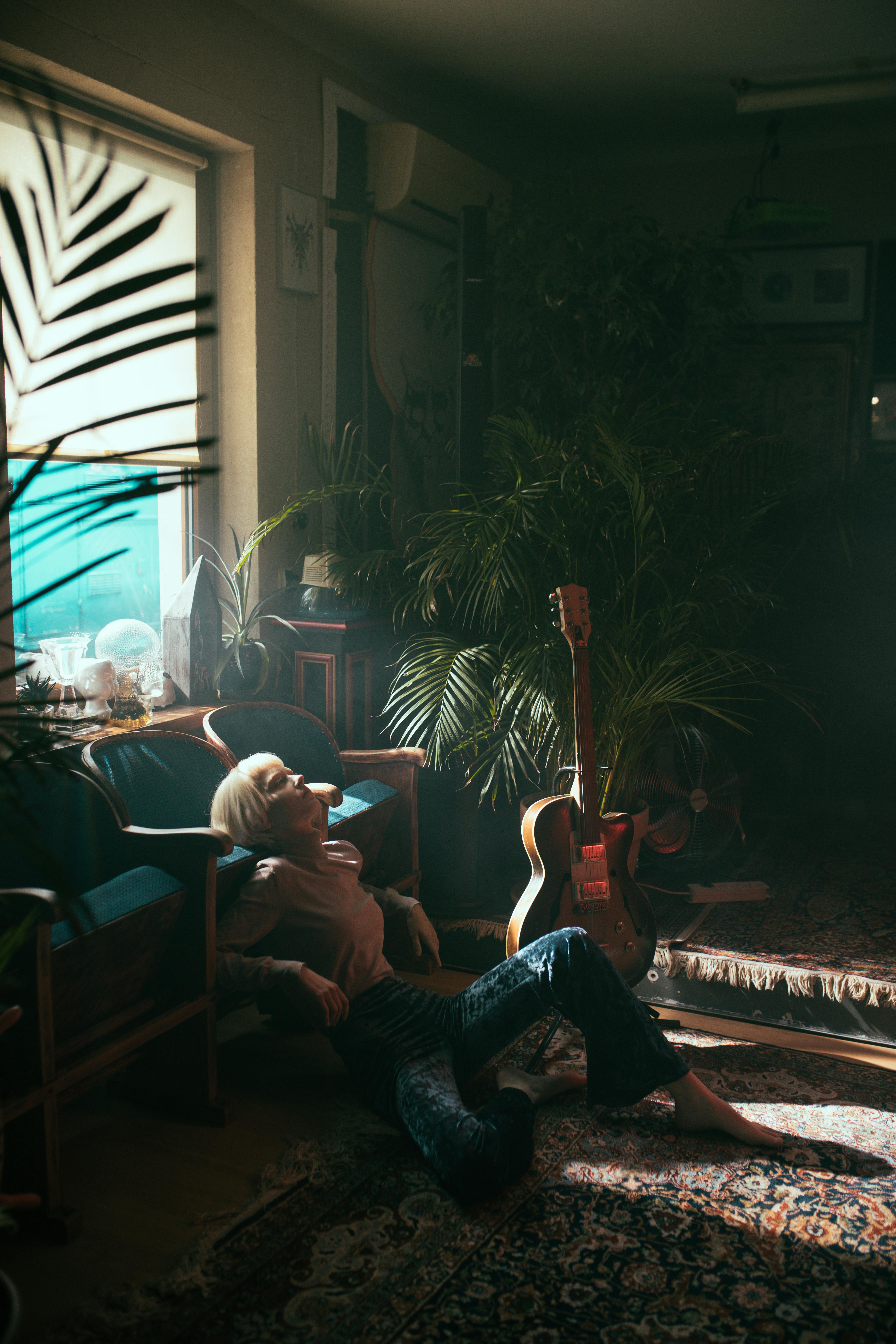 Man in Black T-shirt Playing Guitar Sitting on Couch