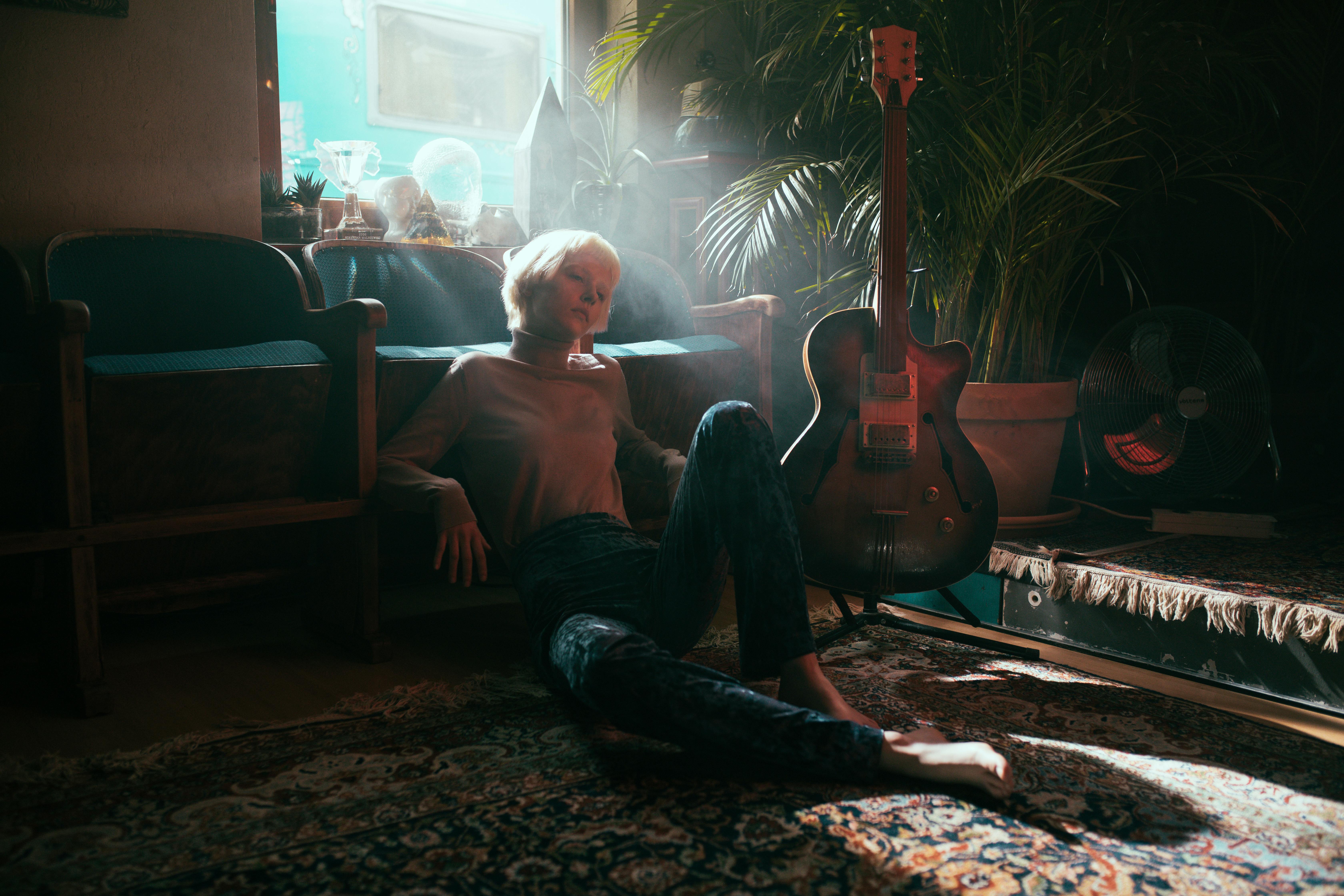Woman in Red Tank Top Sitting on Brown Sofa Chair