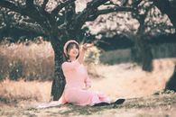 Woman in Pink Dress Sitting on Ground Under a Tree