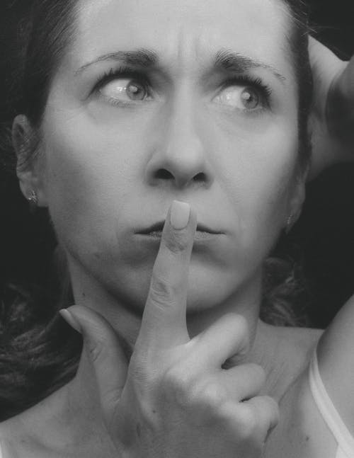 Monochrome Photo of a Woman Putting Her Finger on Her Lip