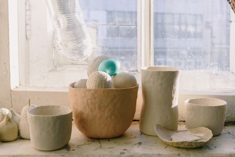 Fresh unfired bowls and vessels resting on the studio windowsill