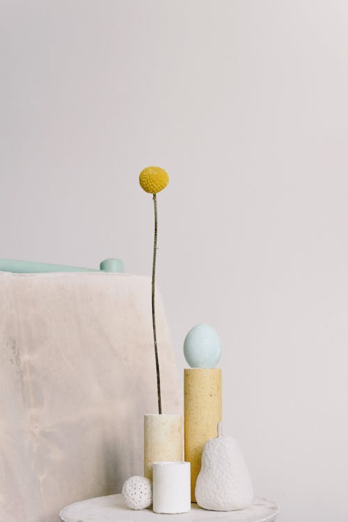 A Yellow Flower and Eggs on Cylindrical Vases