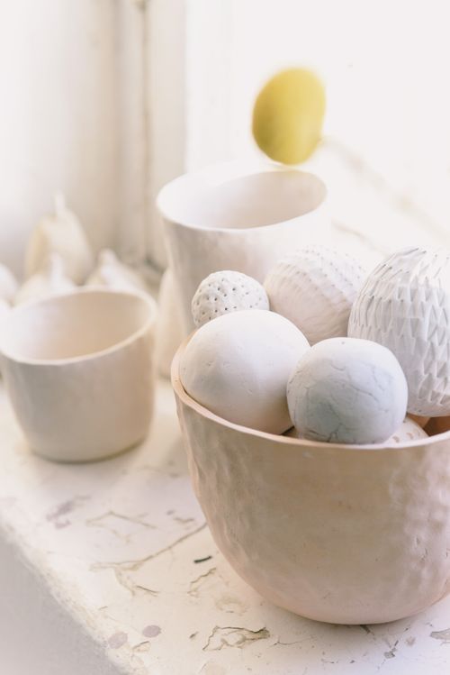 Free Softly lit composition of ceramic bowls and textured spheres on a rustic surface. Stock Photo