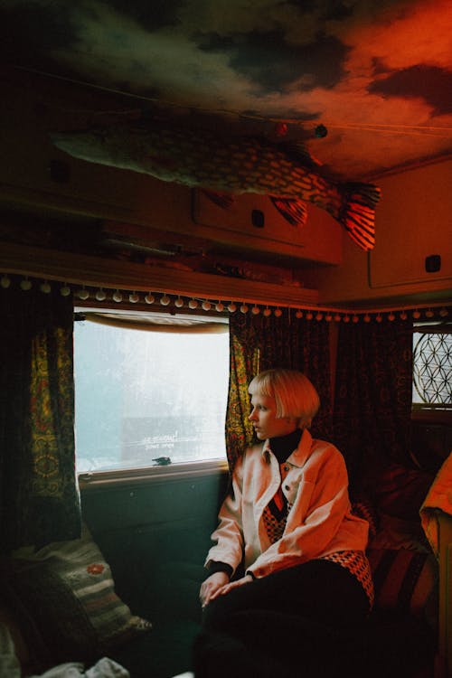 A Woman Sitting Beside the Car Glass Window