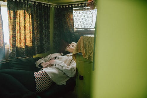 Woman in White Shirt Lying on Bed