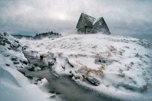 Серый дом в окружении снега