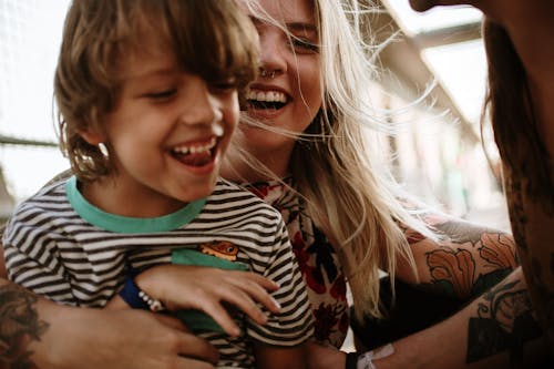 Free Close-Up Photograph of a Child Laughing with His Mother Stock Photo