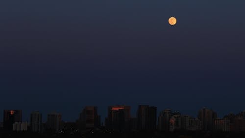 Free Full Moon Over the City Buildings during Night Time Stock Photo