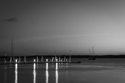 Grayscale Photo of Dock on Sea