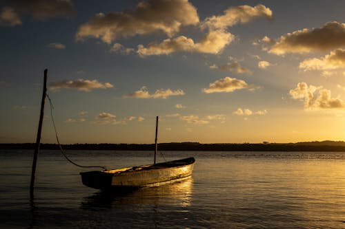 Photo of a Boat Tied to a Wooden Pole