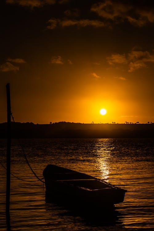 Silhouette of Boat Floating in the Sea During Sunset