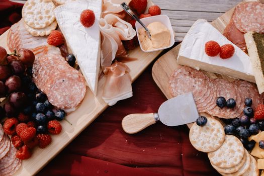 Top view of a charcuterie board featuring brie, salami, and fresh fruits, perfect for gatherings.