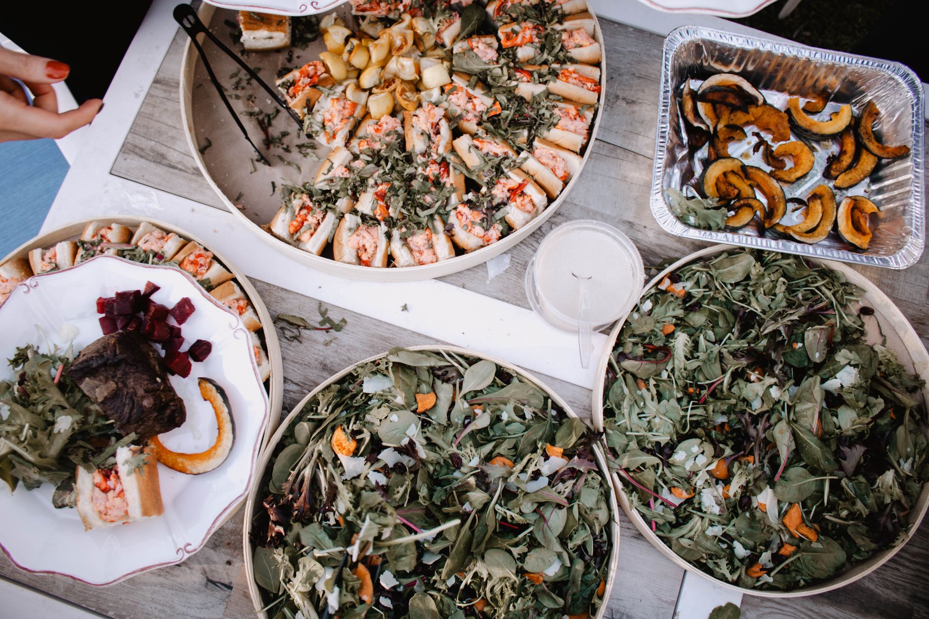 High-angle view of assorted salads and appetizers displayed on a rustic table, featuring fresh ingredients and vibrant colors.