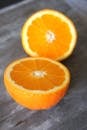 在质朴的表面上，两个新鲜的橙片充满活力地特写，突出其多汁的质地
