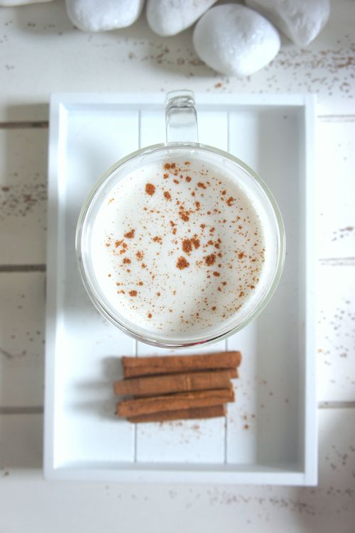Free A creamy cinnamon topped drink in a clear glass mug on a wooden tray, inviting and delicious. Stock Photo