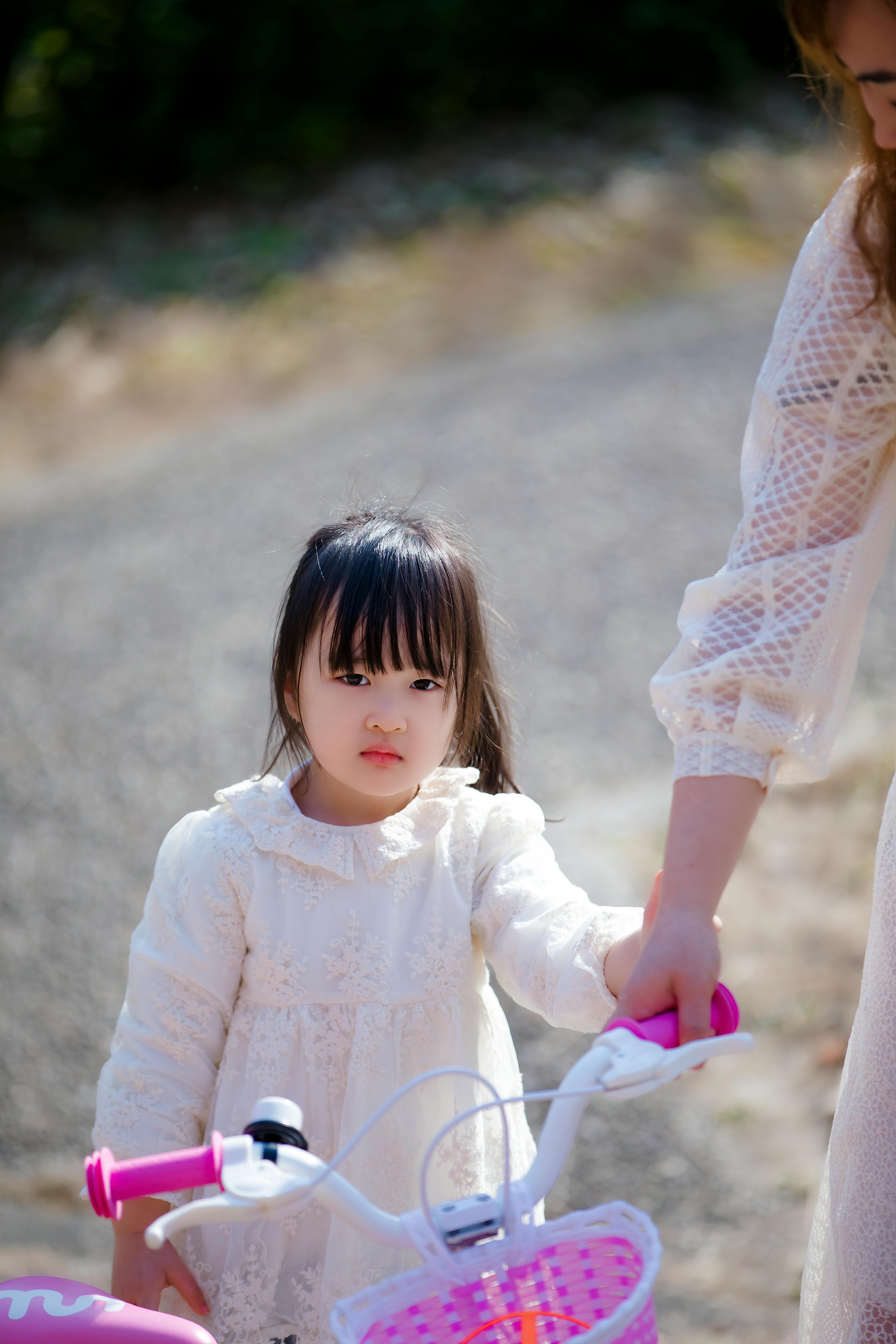 girl wearing a white dress with a bicycle