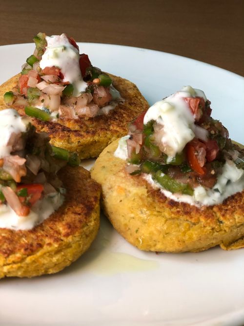 Free Close-up of Mexican corn cakes topped with fresh salsa and cream, on a white plate. Stock Photo