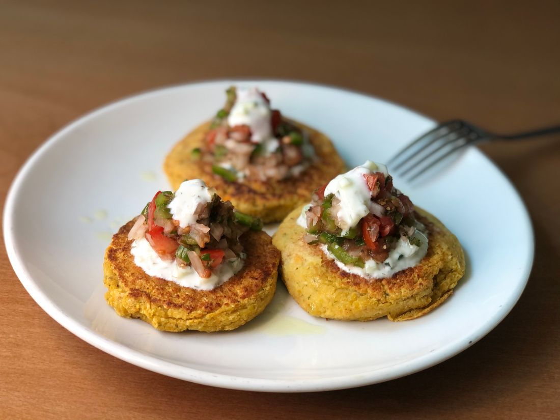 Zucchini fritters served with yogurt and fresh vegetables