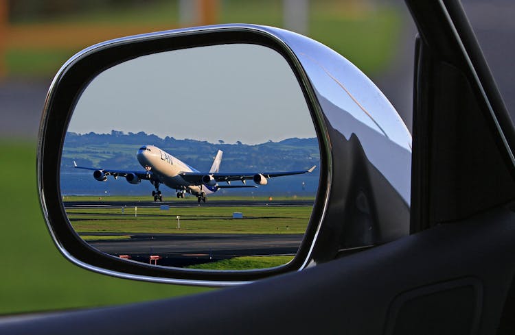 White Airplane Reflection On Car Side Mirror