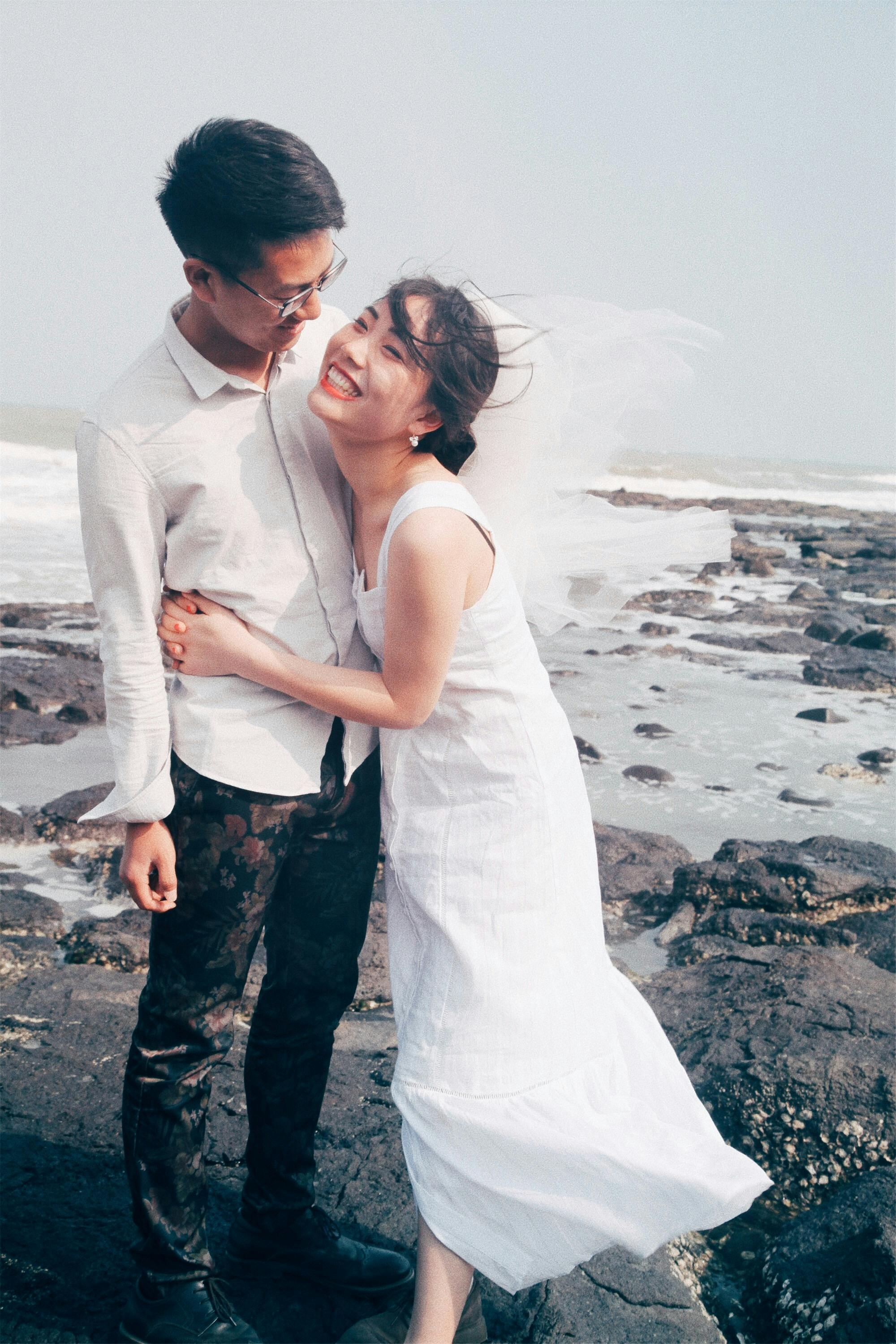 man and woman standing on seashore