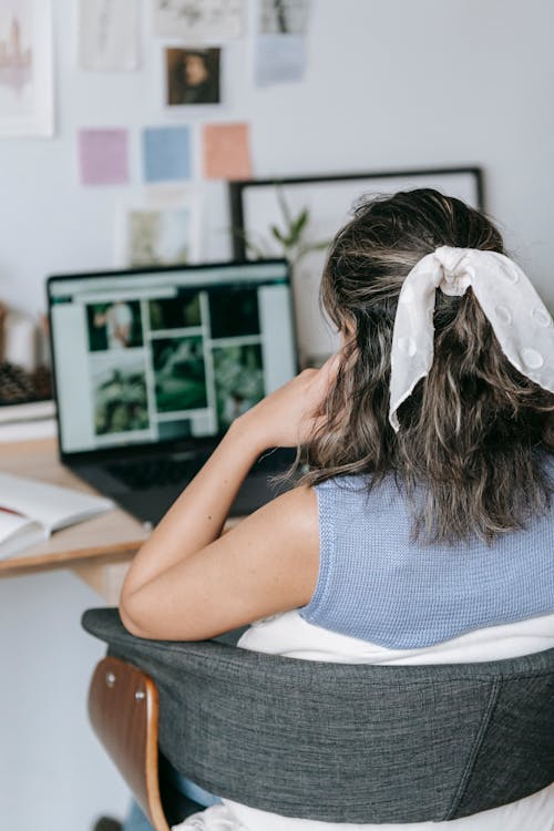 Free Woman browsing laptop while working remotely Stock Photo