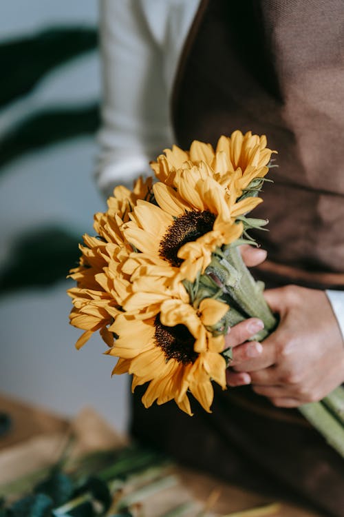 Florist with bunch of fresh sunflowers