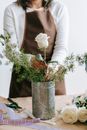 Crop florist making bouquet at work on white background