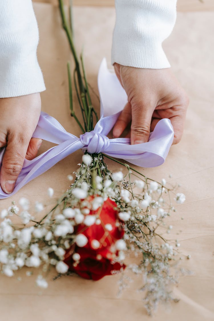 Woman Florist Tying Light Ribbon On Bouquet