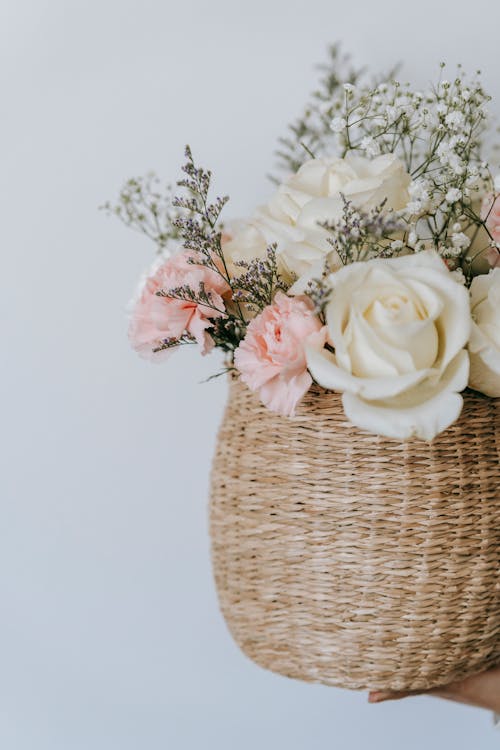 Free Wicker basket with flower bouquet on white background Stock Photo