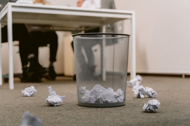 Crumpled Papers Inside The Trash Bin At The Office