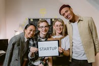 Man in Gray Blazer Holding Black Box