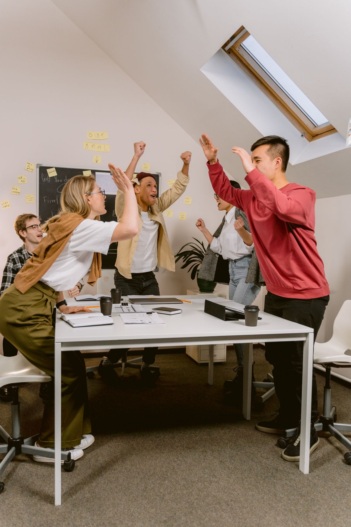 Young professionals celebrating a new Salesforce job offer in an office
