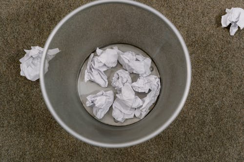 Close-Up Shot of Paper Trashes on a Trash Can