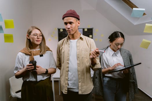 Diverse group brainstorming with tech devices and notes in modern office.